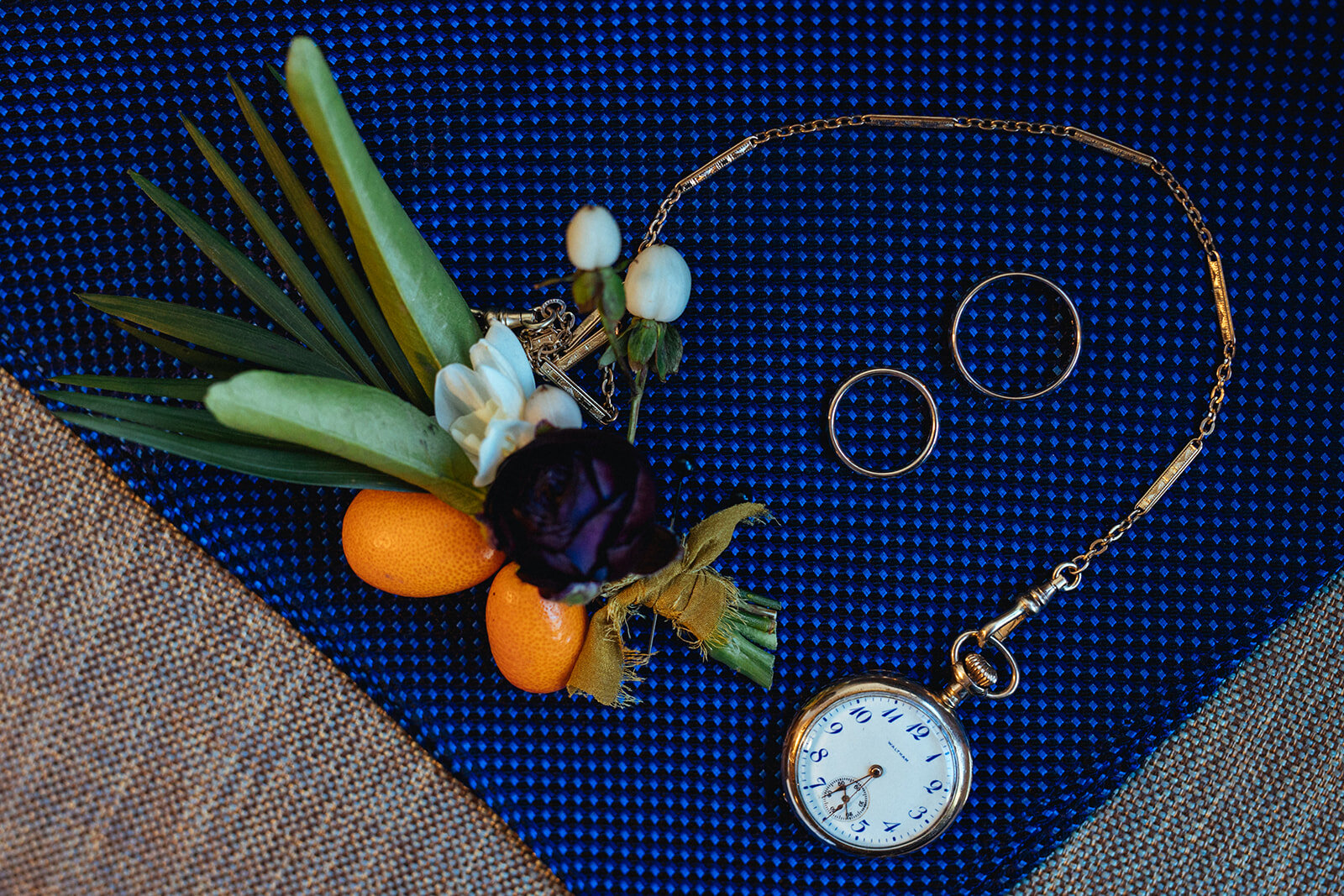 Boutonniere rings and watch displayed in Brooklyn NYC Shawnee Custalow Queer wedding photography