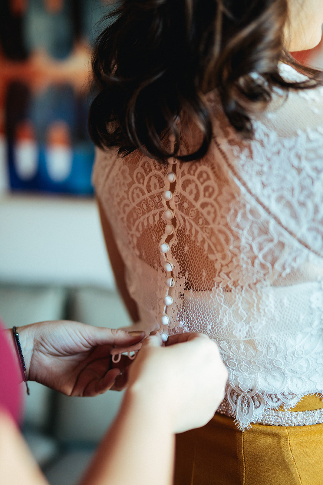 Guest buttoning the brides lace top in Brooklyn NYC Shawnee Custalow wedding photography