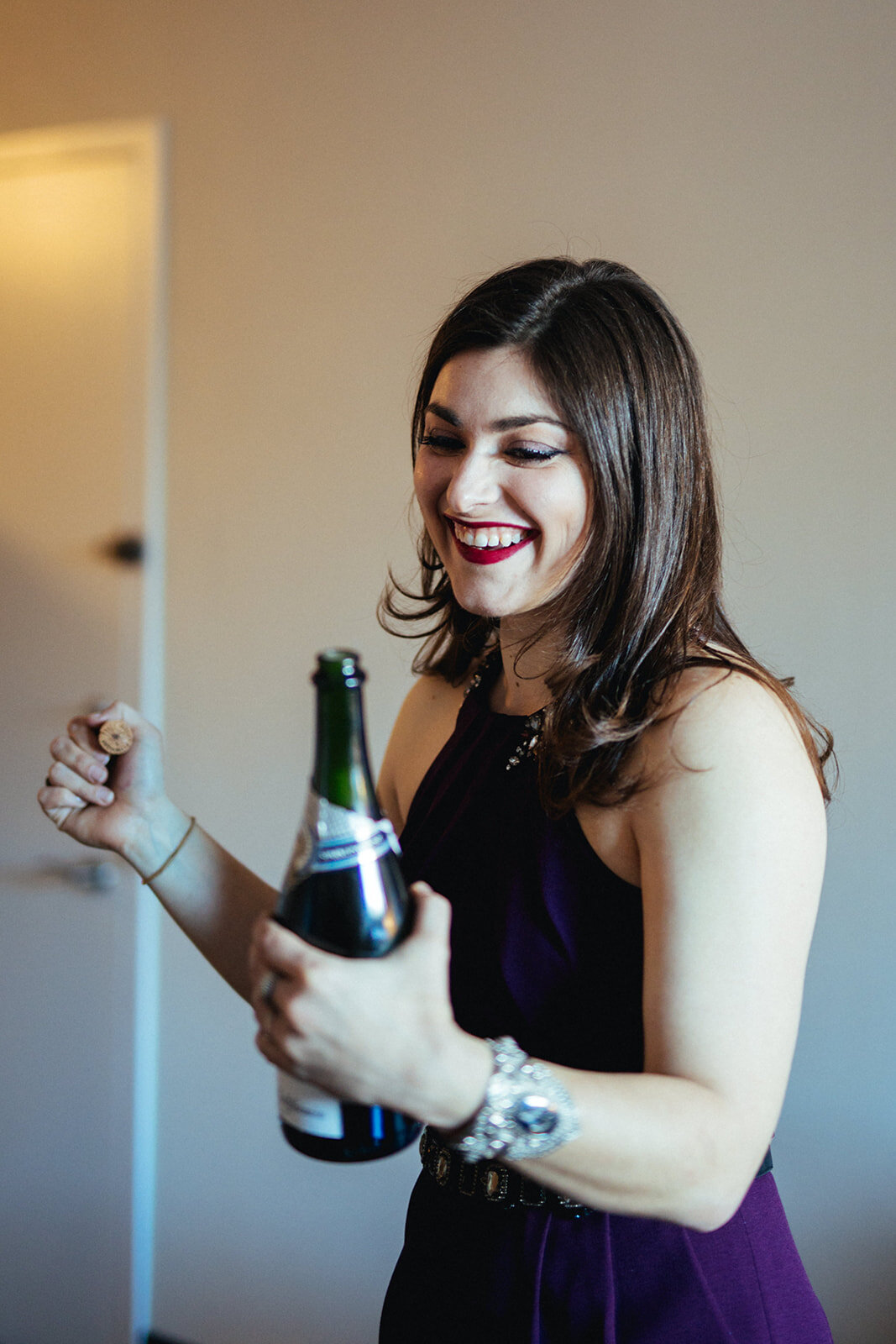 Bridesmaid popping champagne in Brooklyn NY Shawnee Custalow queer wedding photographer