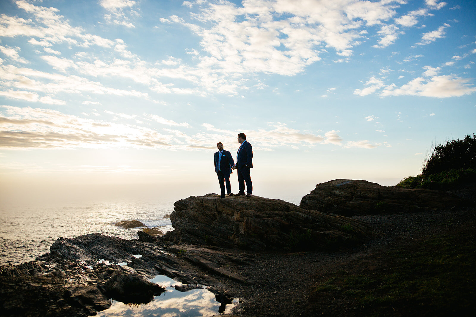 LGBTQ couple on a rock by the sea on Peaks Island Portland ME Shawnee Custalow Queer wedding photography