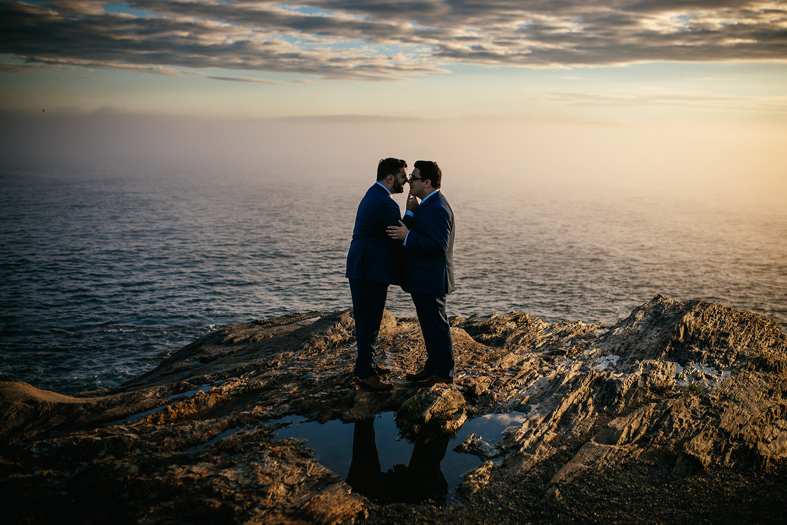 LGBTQ couple leaning in for a kiss by the ocean onPeaks Island Portland ME Shawnee Custalow Queer wedding photography