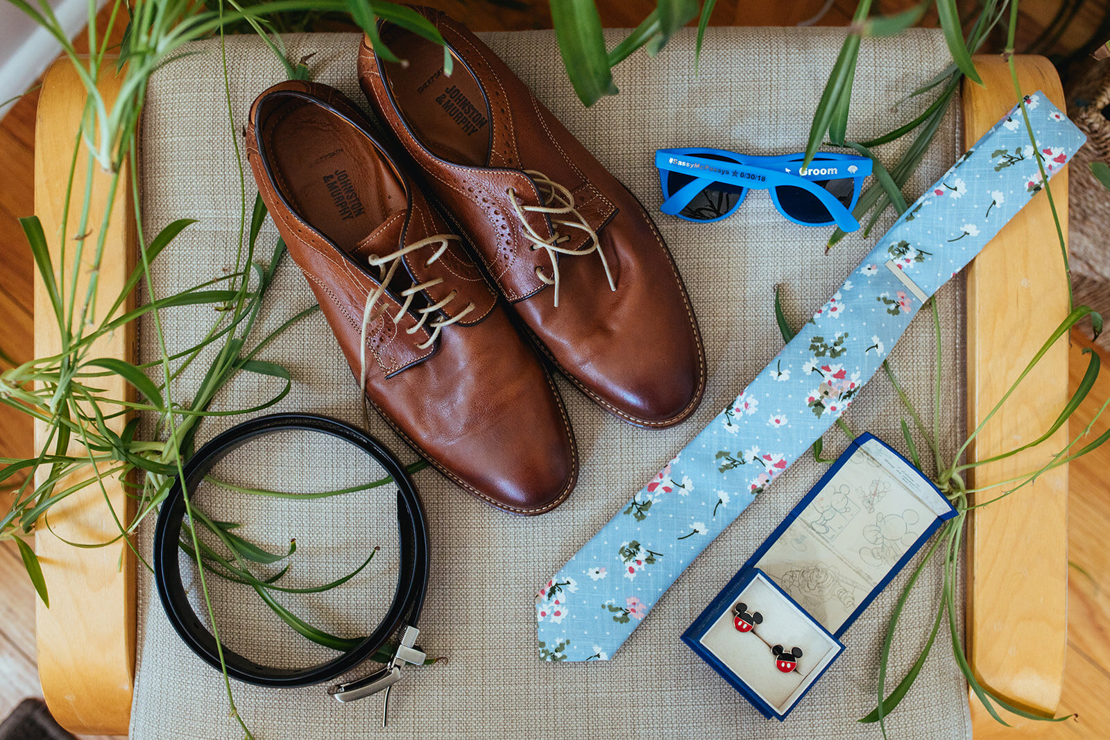 Dress shoes sunglasses tie and cufflinks displayed in Portland ME Shawnee Custalow Queer wedding photography