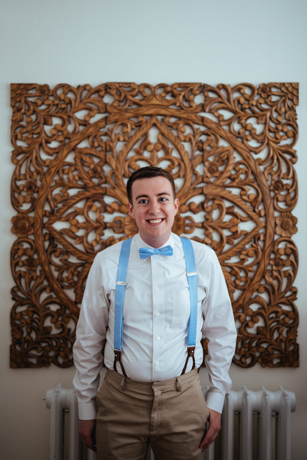 Honor attendant in blue bowtie and suspenders in Portland ME Shawnee Custalow Queer wedding photography
