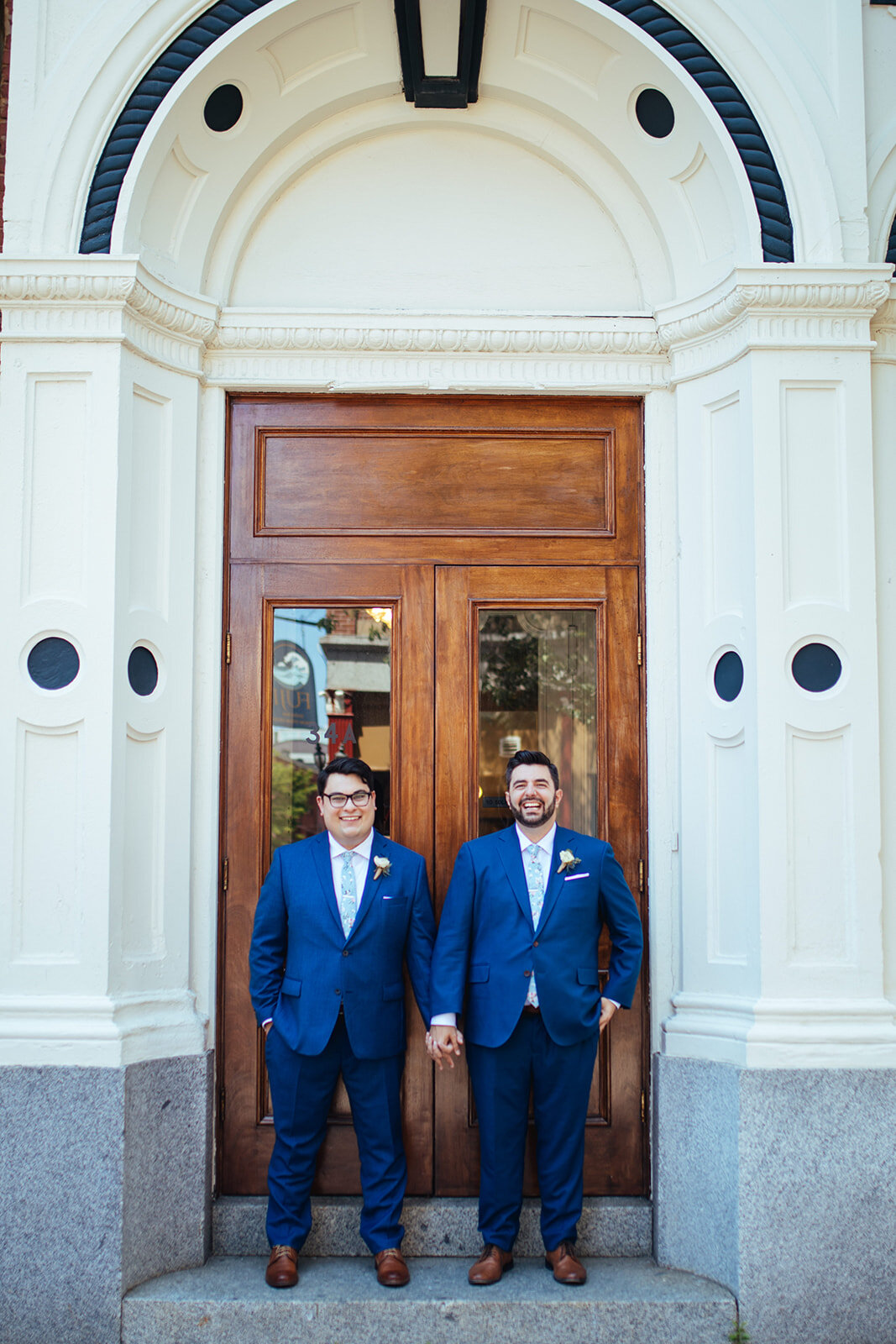 Same sex couple holding hands in downtown Portland ME Shawnee Custalow Queer wedding photography