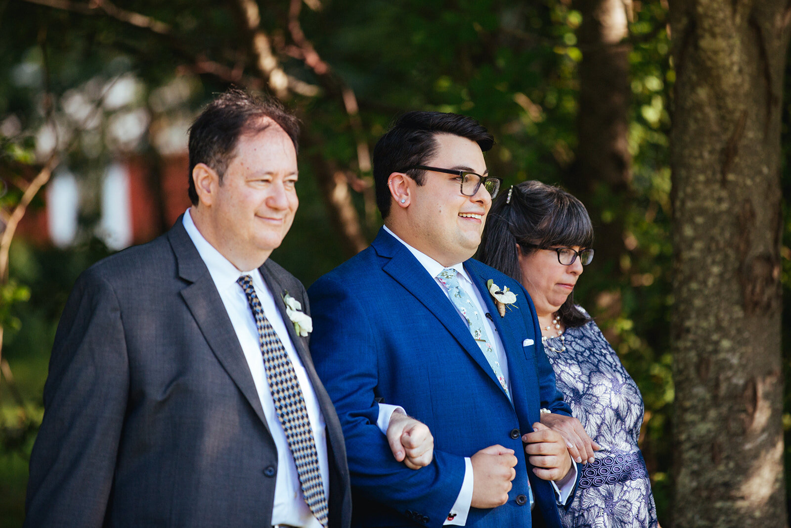 Groom escorted to the ceremony by parents in Portland ME Shawnee Custalow Queer wedding photography