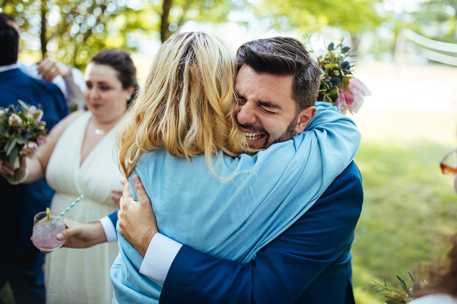 Newlywed hugging guests on peaks island Portland ME Shawnee Custalow Queer wedding photography