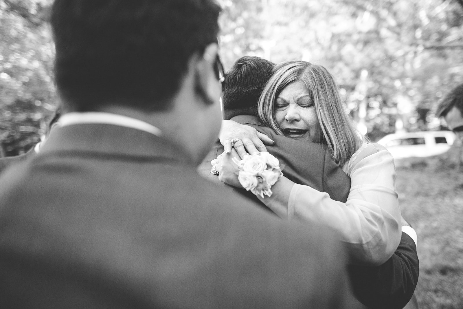 Emotional guest hugging newlywed spouse inPortland ME Shawnee Custalow Queer wedding photography