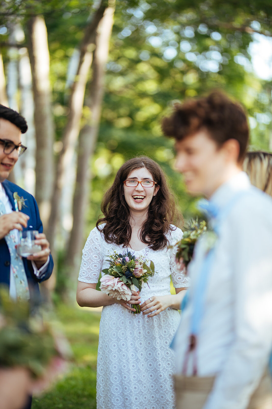 Happy honor attendant with bouquet on Peaks Island Portland ME Shawnee Custalow Queer wedding photography