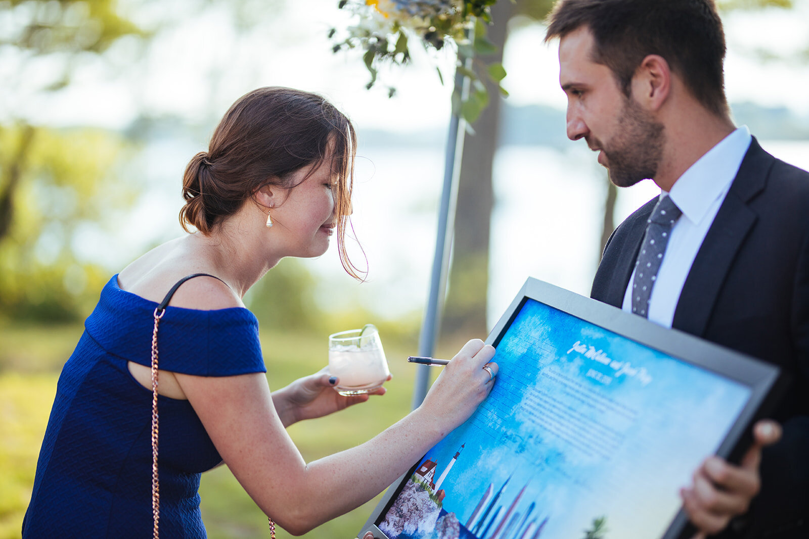 Wedding guest signing poster on Peaks Island Portland ME Shawnee Custalow Queer wedding photography