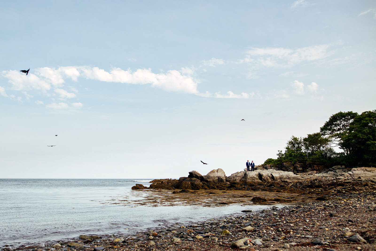 Newlyweds on a rocky beach on Peaks Island Portland ME Shawnee Custalow Queer wedding photography