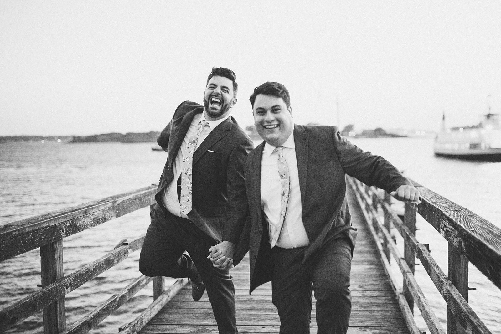 Newlyweds playing on a pier in Portland ME Shawnee Custalow Queer wedding photography