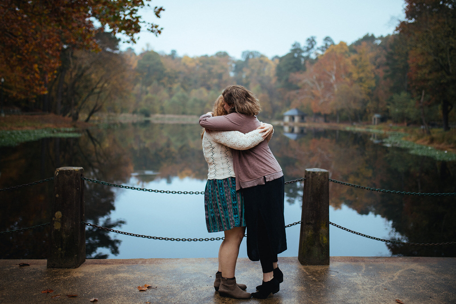 Engaged couple hugging on a Forest Hill Park bridge RVA Shawnee Custalow photography