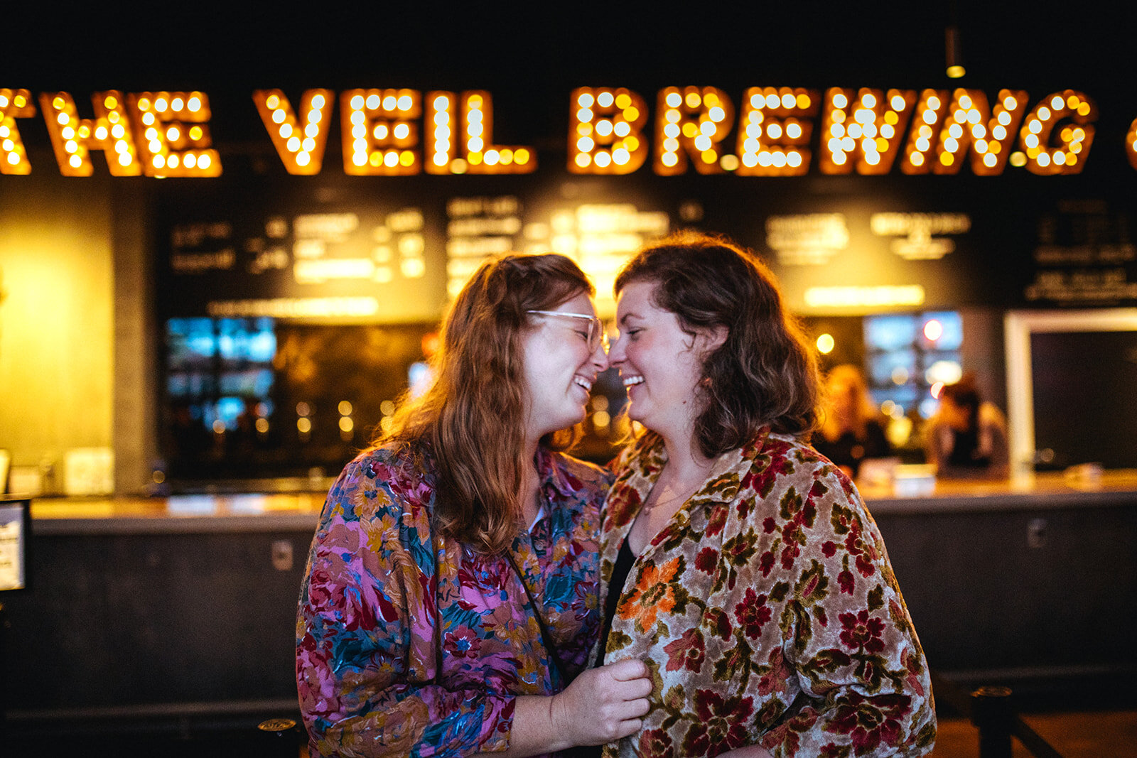 LGBTQ engaged couple lean in to kiss at The Veil Brewing Co RVA Shawnee Custalow photography