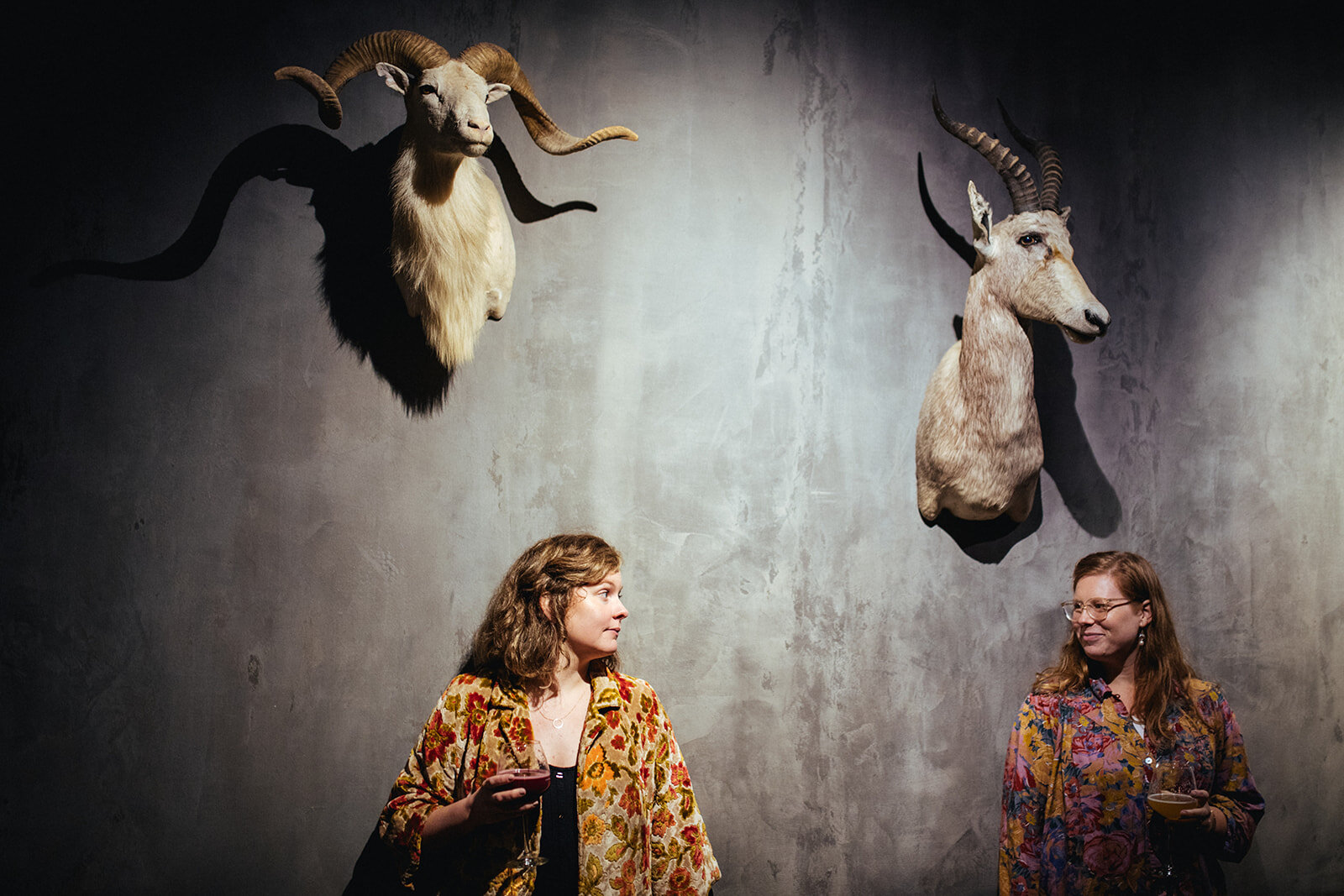 Engaged couple by wall deer busts at The Veil Brewing Co RVA Shawnee Custalow photography