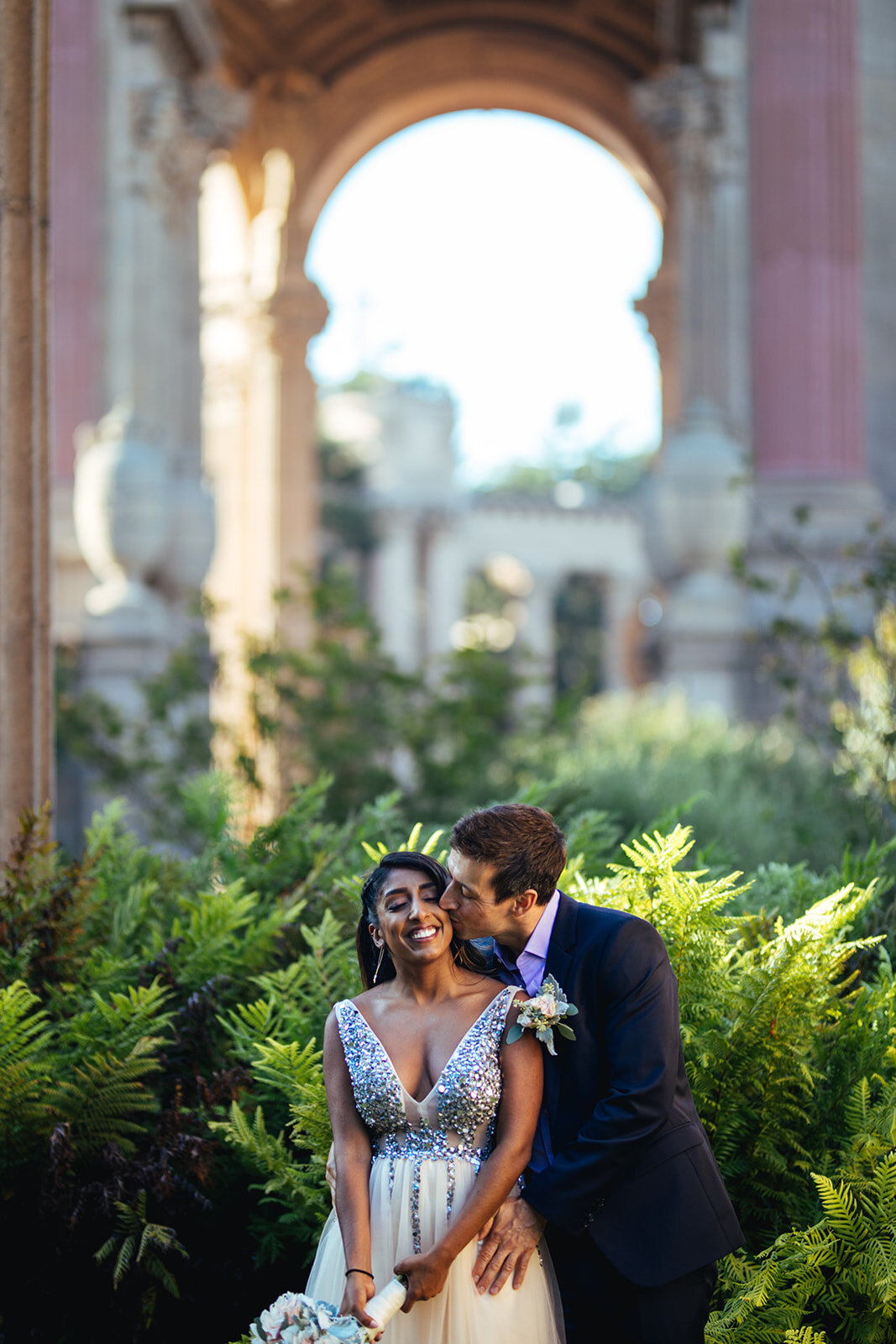 Groom kissing the bride at the Palace of Fine Arts Shawnee Custalow