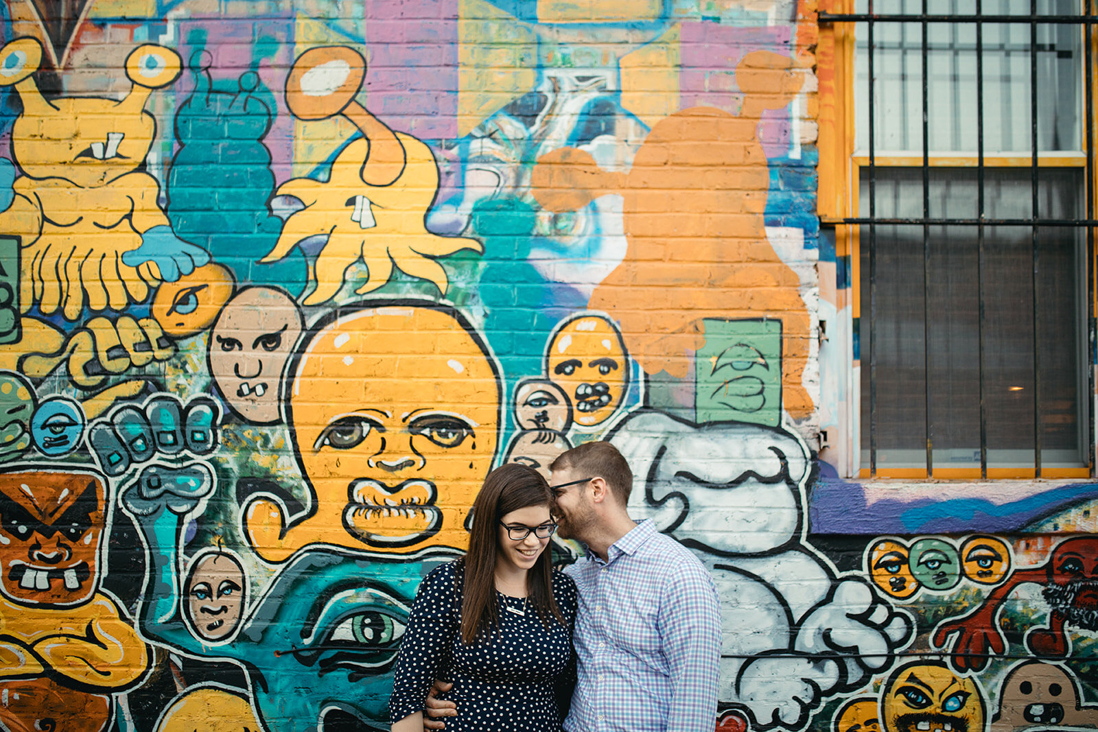 Engaged couple by an art mural in DC Shawnee Custalow photography