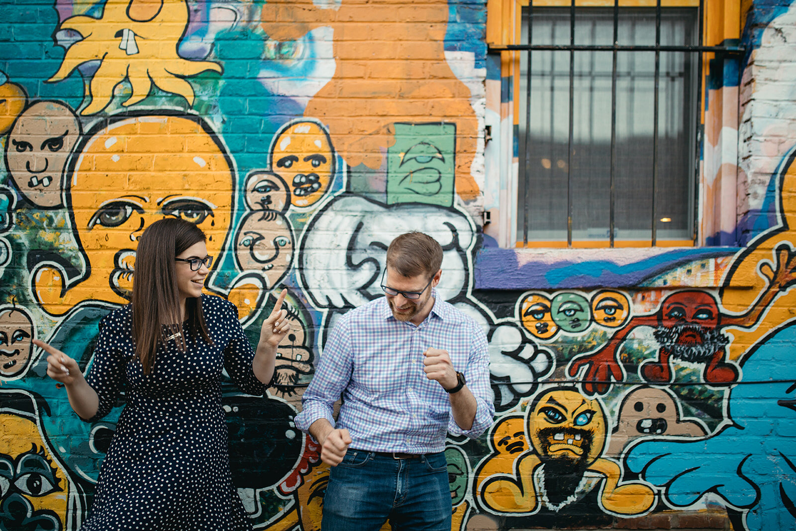 Engaged couple by an art mural in DC Shawnee Custalow photography