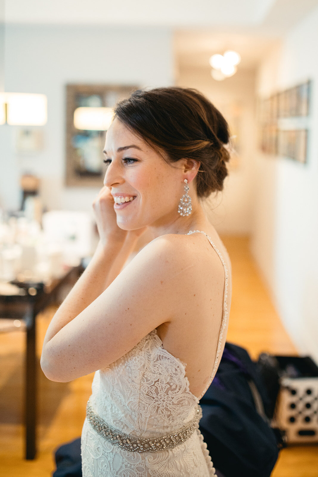 Bride putting on earring in Brooklyn home NYC Shawnee Custalow wedding photography