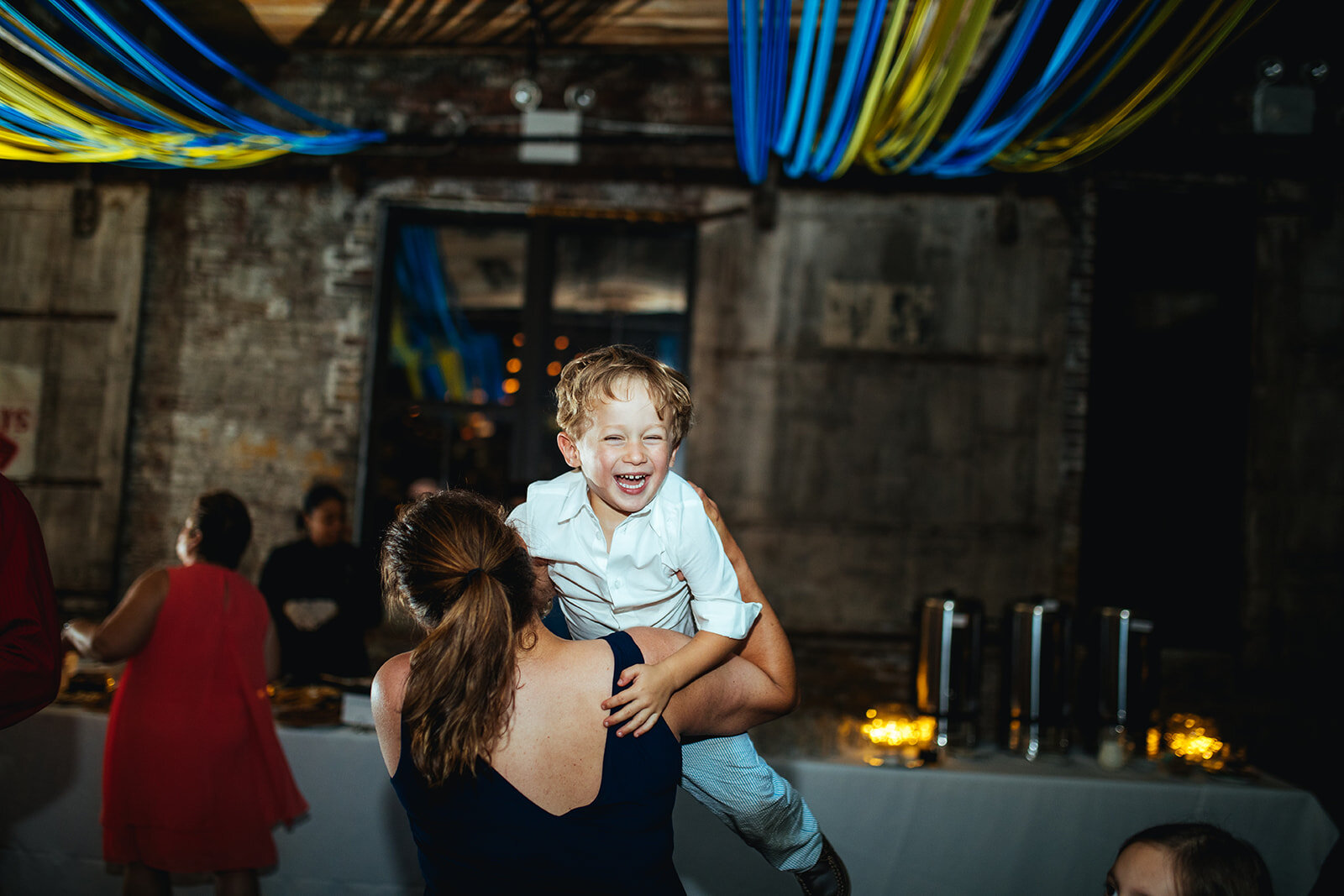 Wedding guest holding a boy at the Greenpoint Loft Brooklyn NYC Shawnee Custalow photography