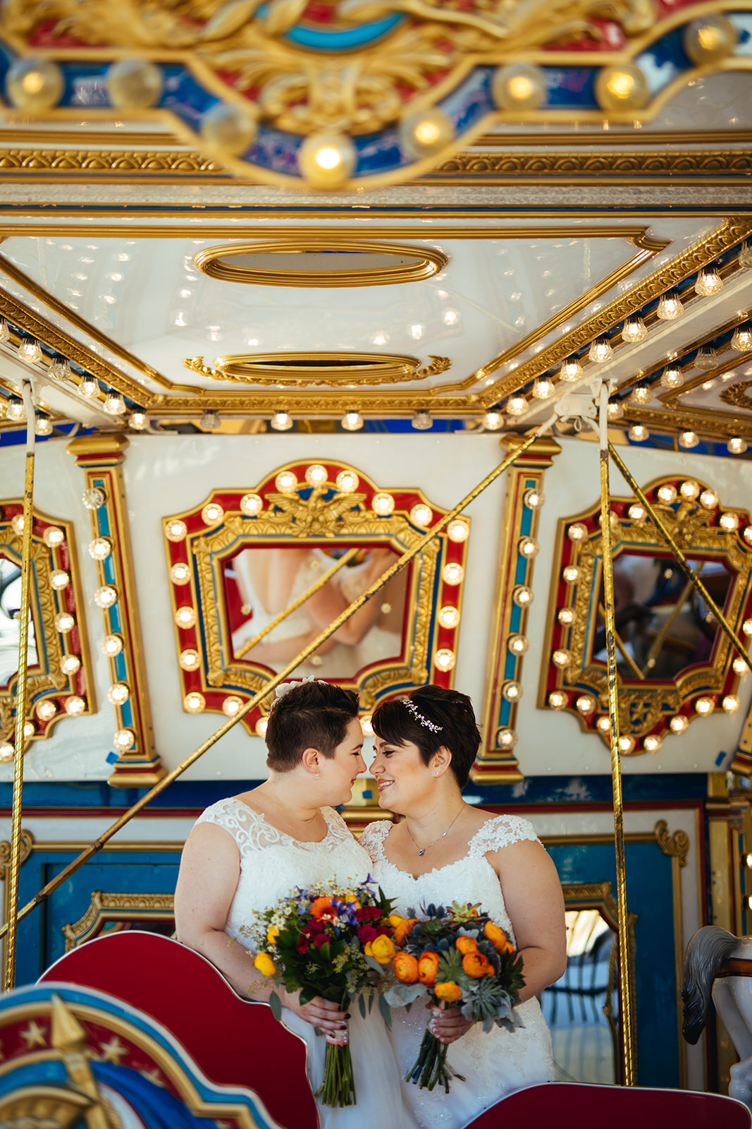Queer spouses lean in to kiss on a carousel near DC Shawnee Custalow wedding photography