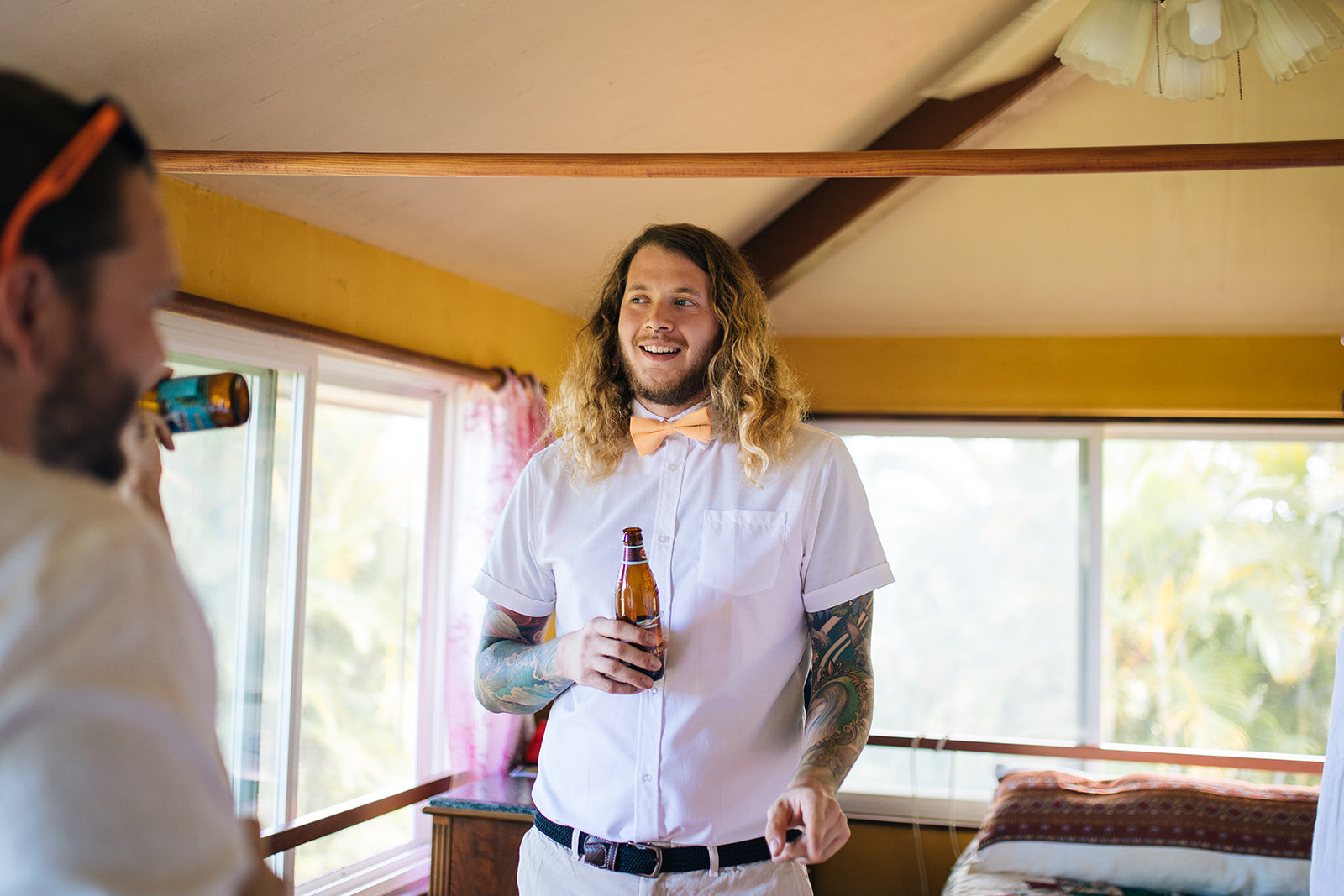 Groom in bowtie drinking beer in Kauai Hawaii Shawnee Custalow wedding photography