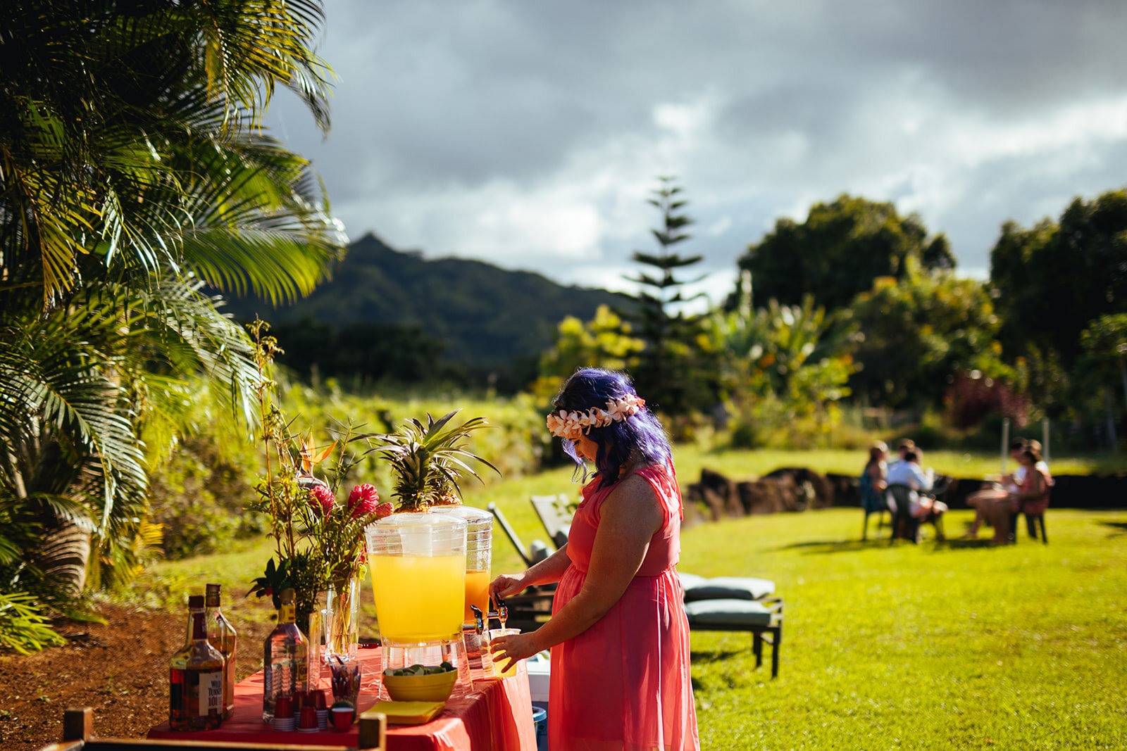 Wedding guest pouring a drink at Kauai HI reception Shawnee Custalow photography