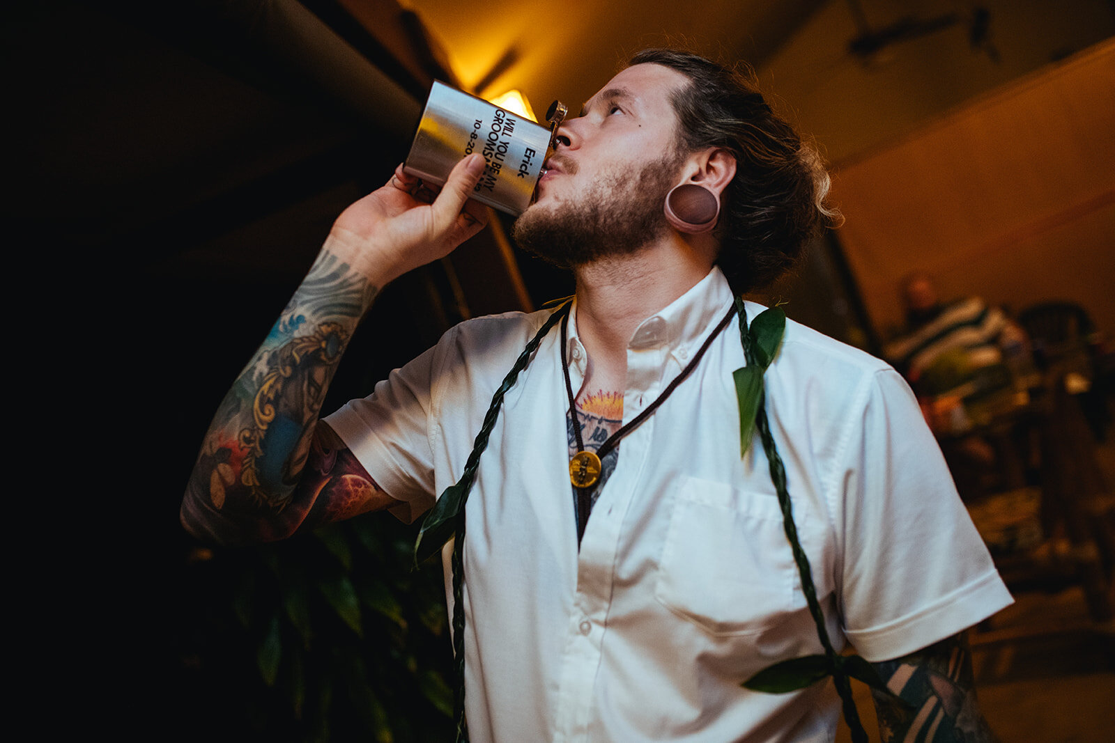 Groom drinking from a flask at Kauai HI reception Shawnee Custalow wedding photography