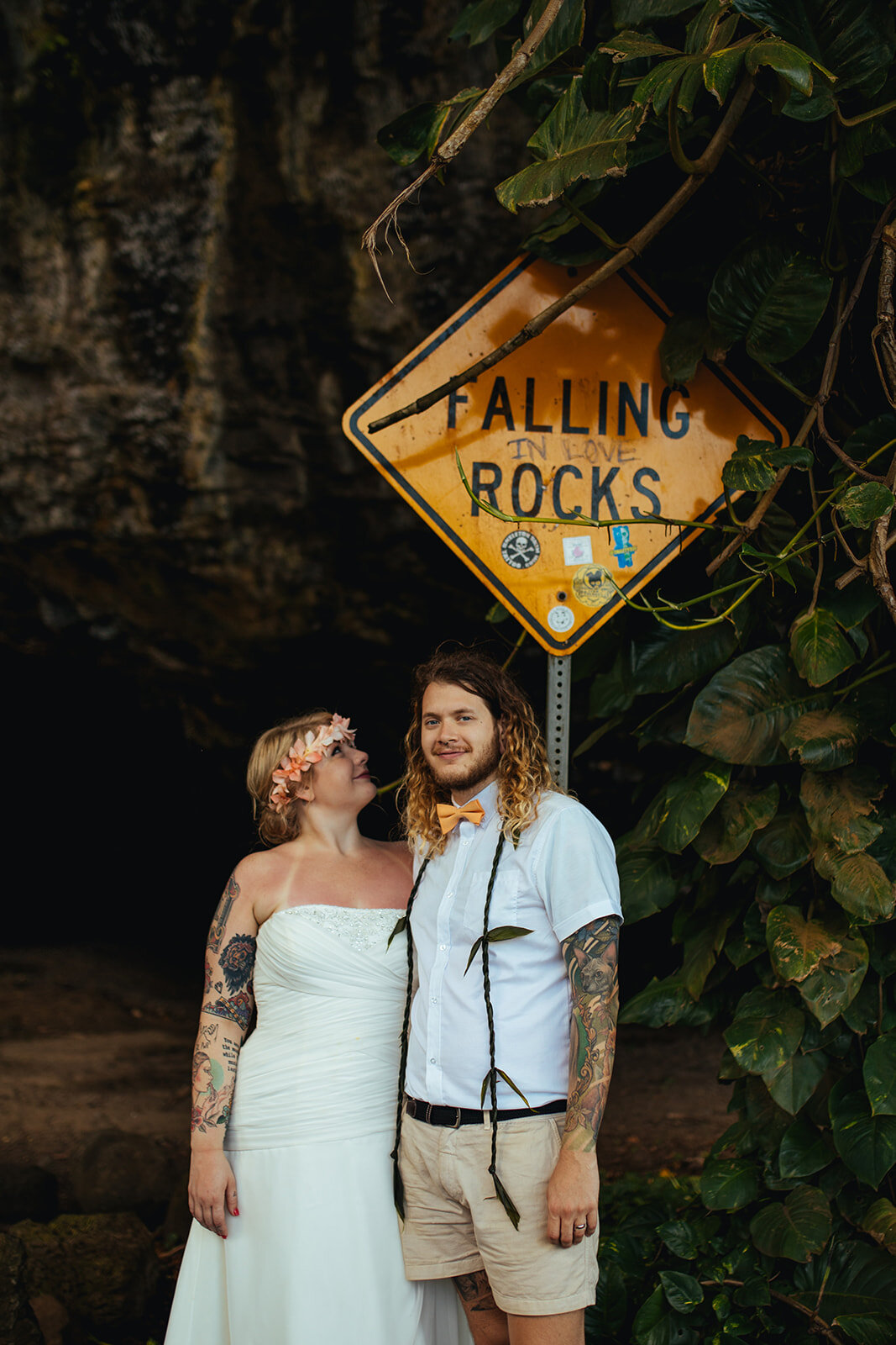 Newlyweds under a falling rock sign in Kauai Hawaii Shawnee Custalow photography