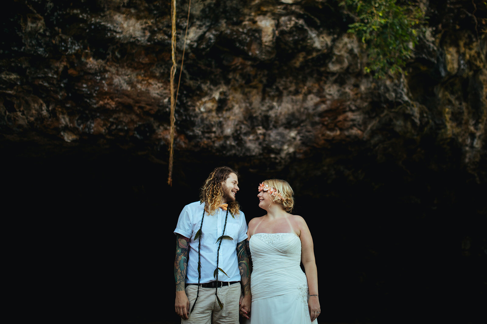 Newlyweds holding hands by a cave in Kauai Hawaii Shawnee Custalow wedding photography
