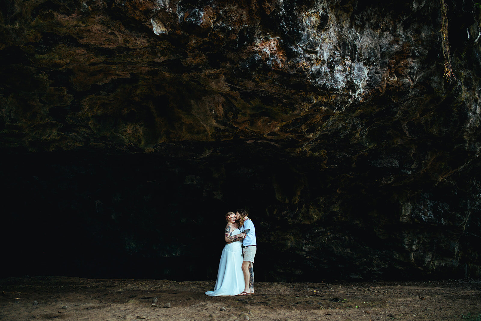 Newlyweds embracing by a cave in Kauai Hawaii Shawnee Custalow wedding photography