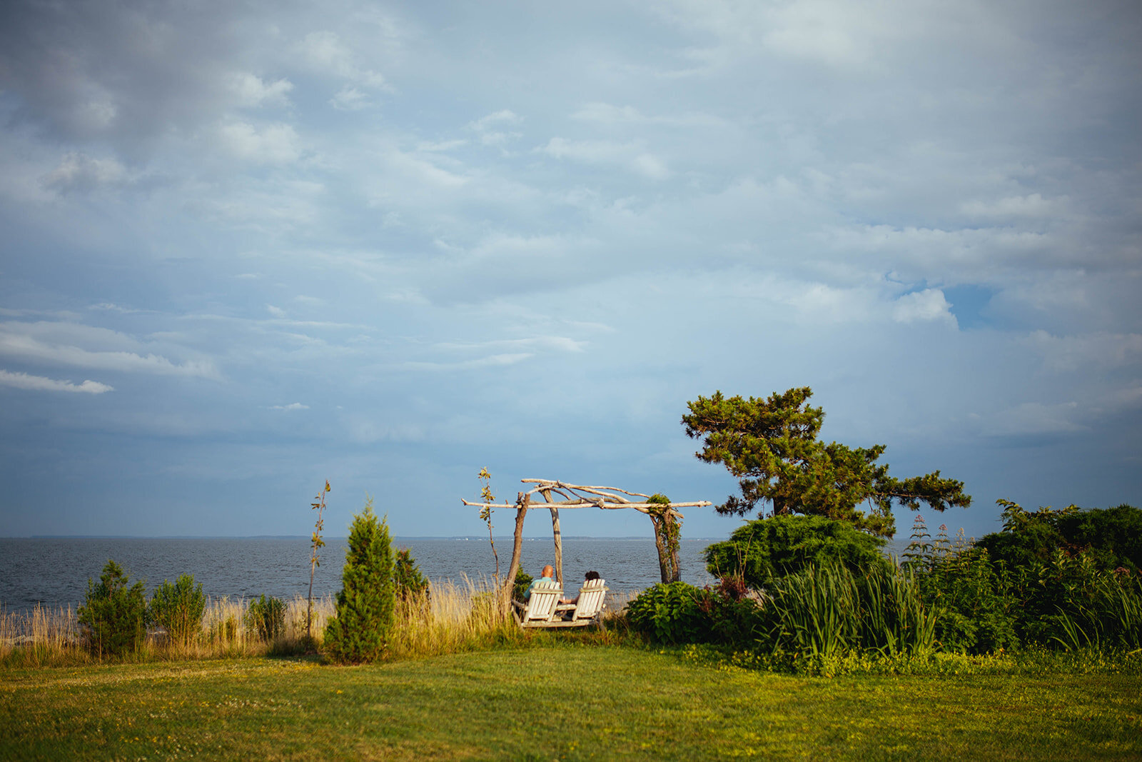 Guests sitting by the sea on Tilghman Island MD Shawnee Custalow wedding photography