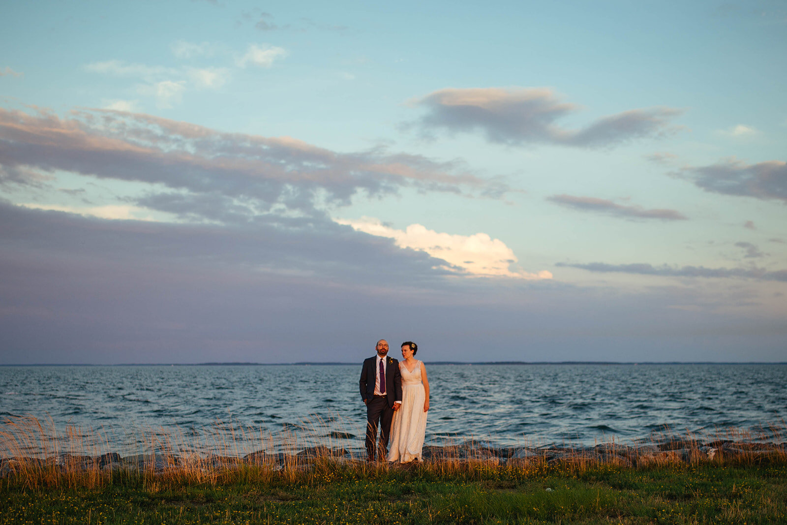Newlyweds holding hands by the ocean on Tilghman Island MD Shawnee Custalow photography
