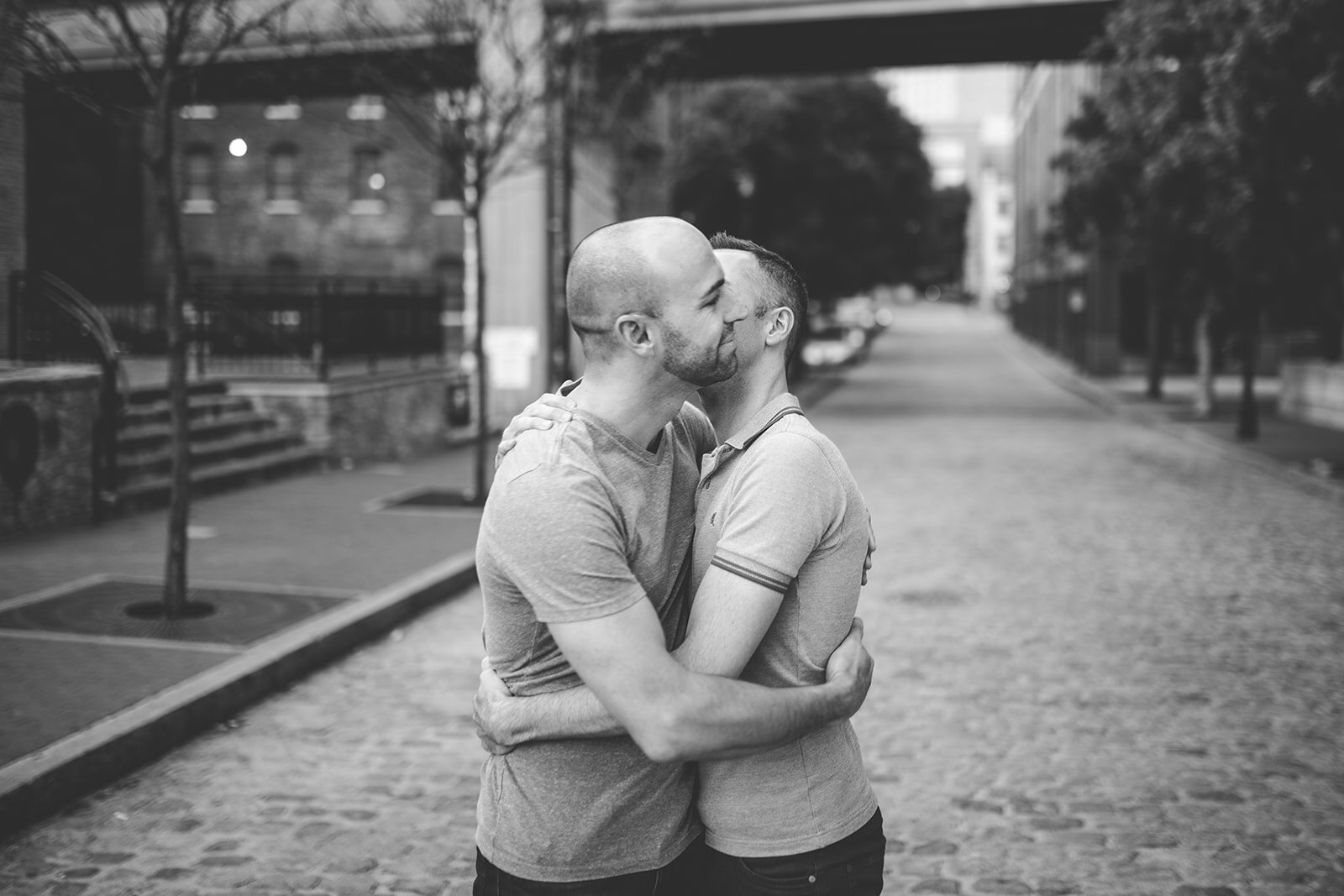 LGBTQ couple lean in to kiss in downtown Richmond VA Shawnee Custalow photography