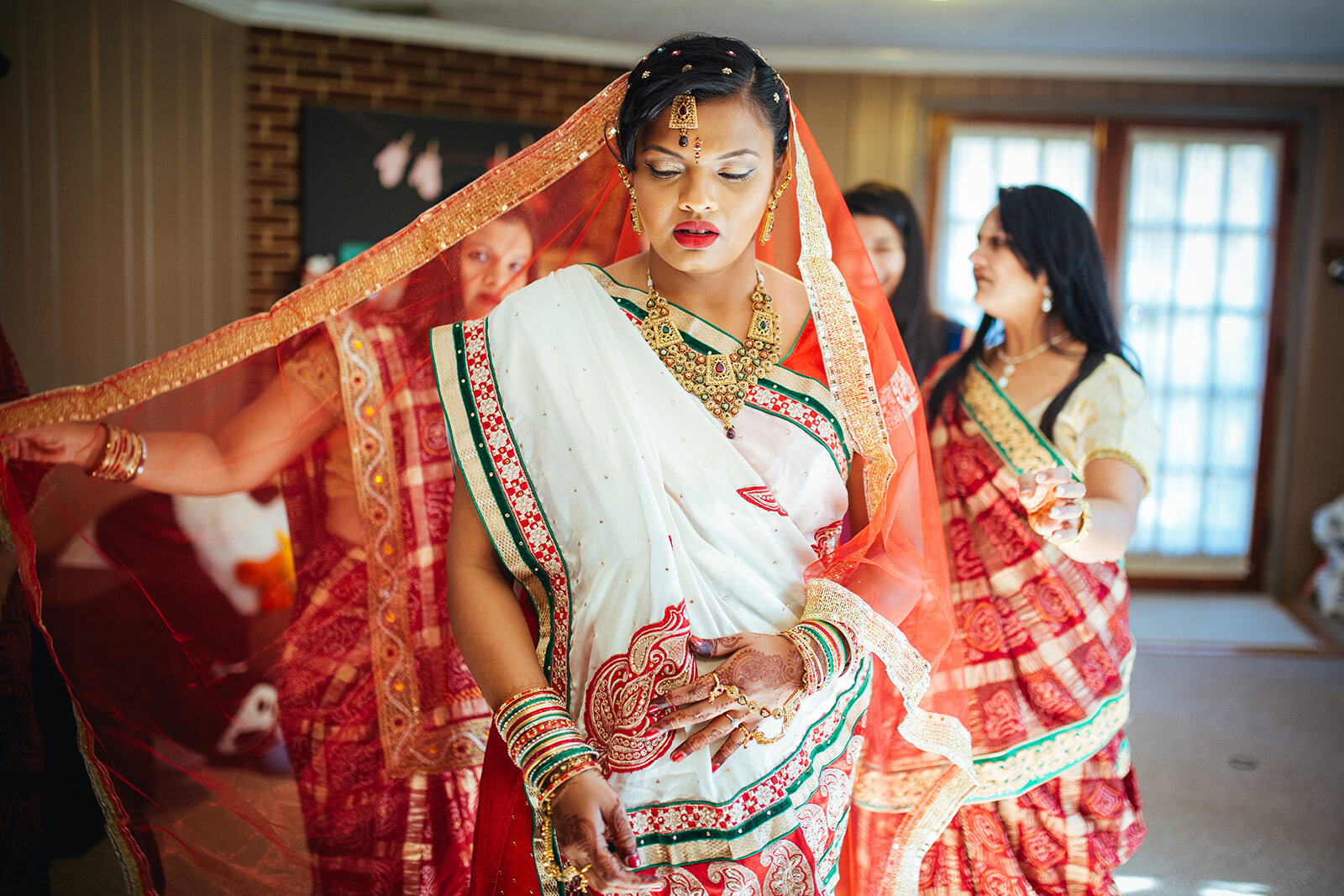 Bride putting on traditional red Sari in Richmond VA Shawnee Custalow photography