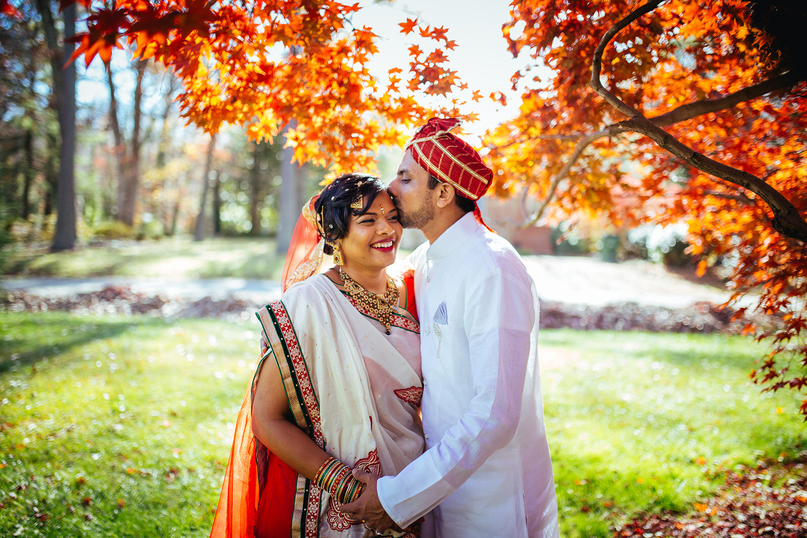 Groom kissing brides forehead under a red tree in Richmond VA Shawnee Custalow photography