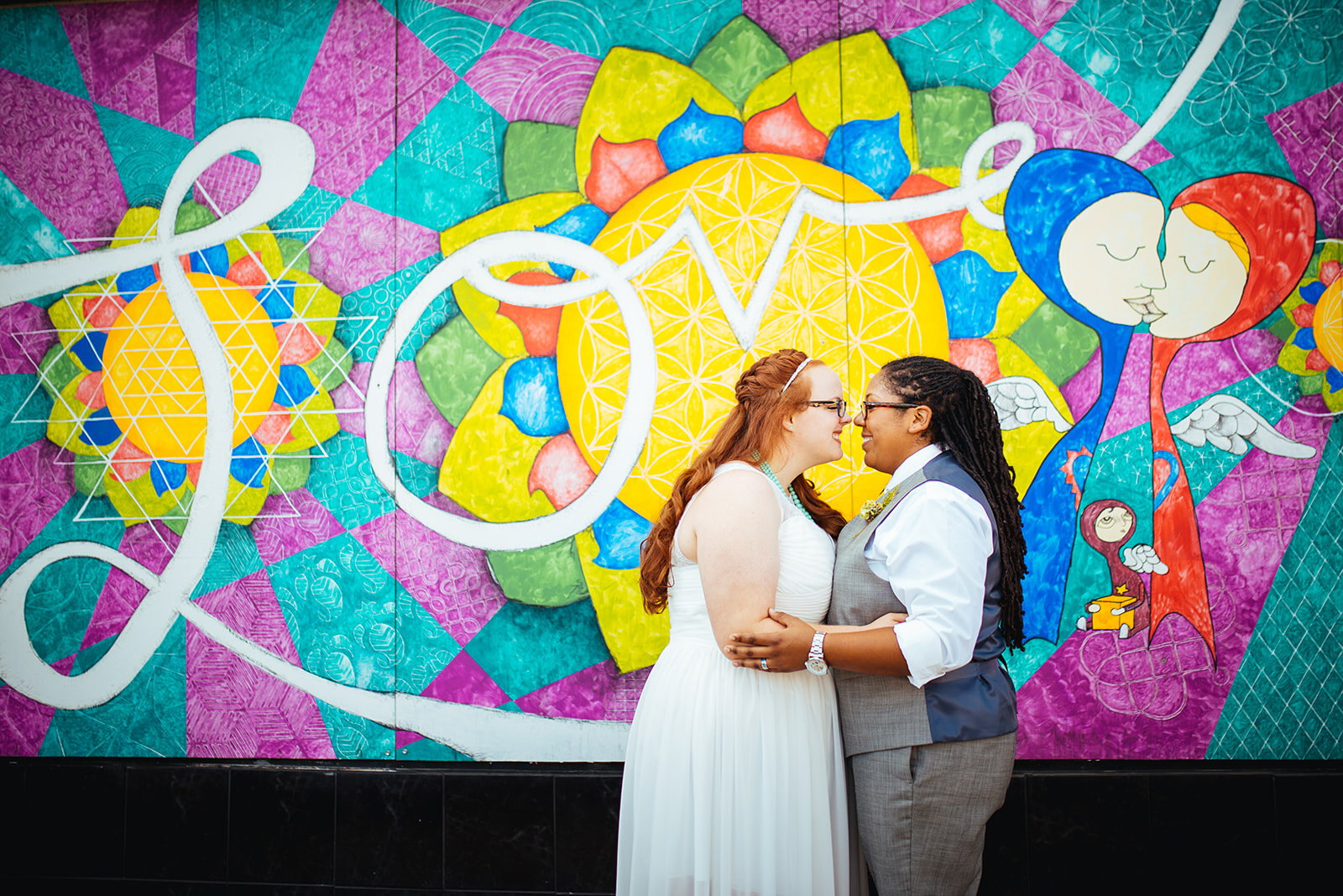 Newlyweds touching noses by a mural in Norfolk VA Shawnee Custalow wedding photography