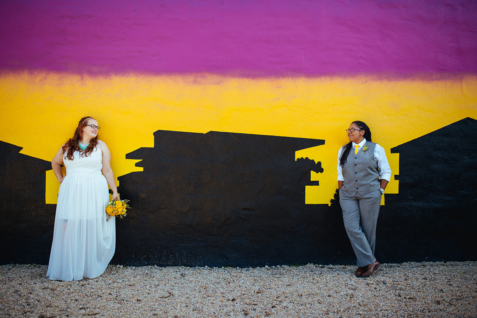 Newlyweds standing apart by a mural in Norfolk VA Arts District Shawnee Custalow photography