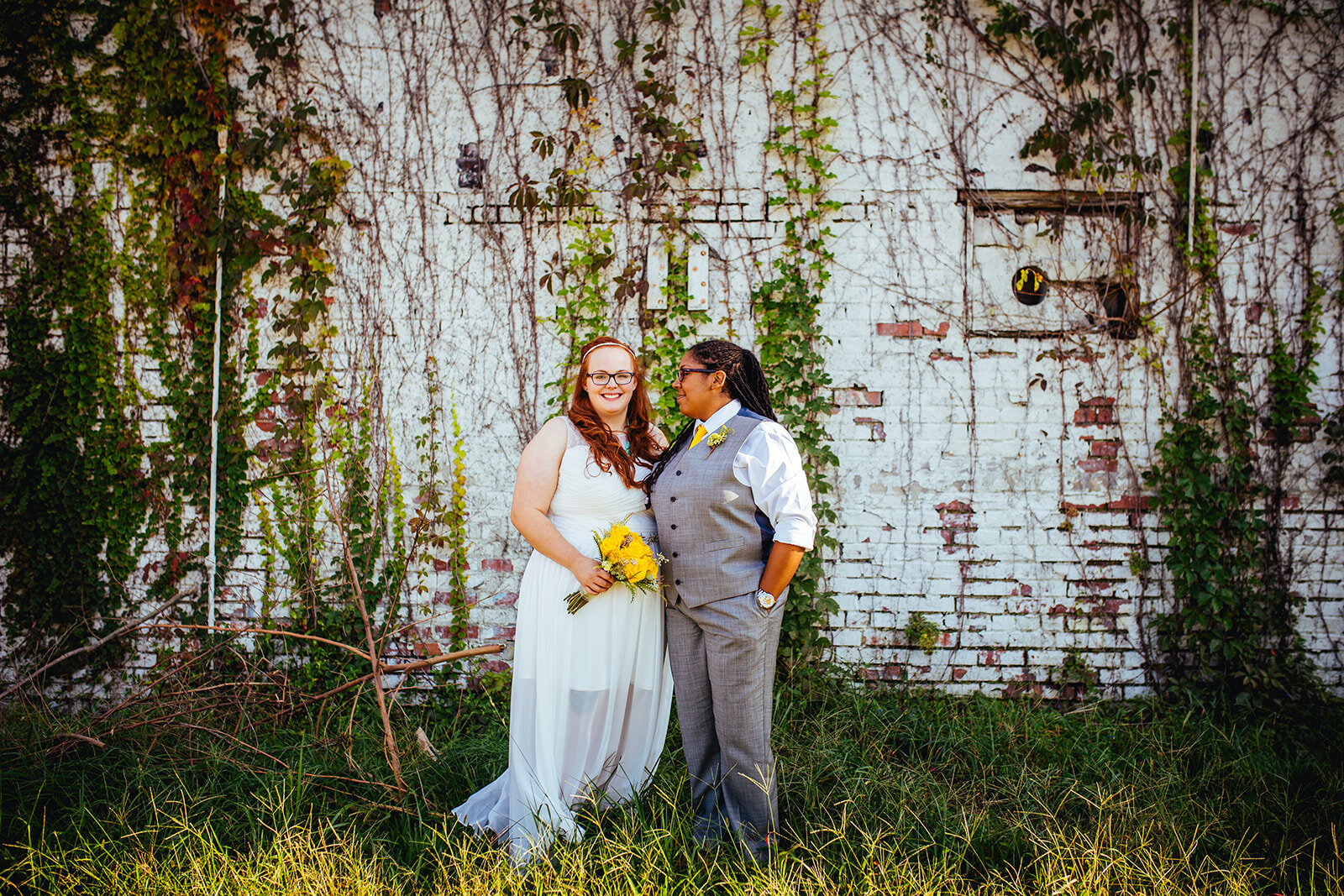 LGBTQ spouses by an overgrown brick wall in Norfolk VA Shawnee Custalow wedding photography