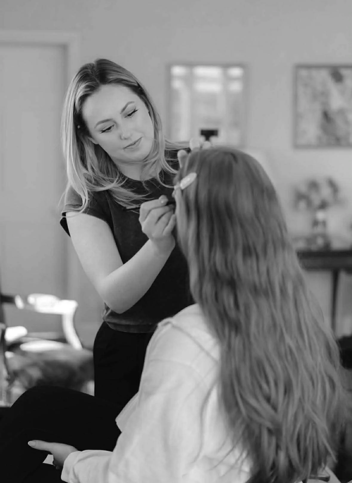 Professional makeup artist Lowri Makeup Artist applying makeup to a client in South Wales, showcasing a calm and considered approach