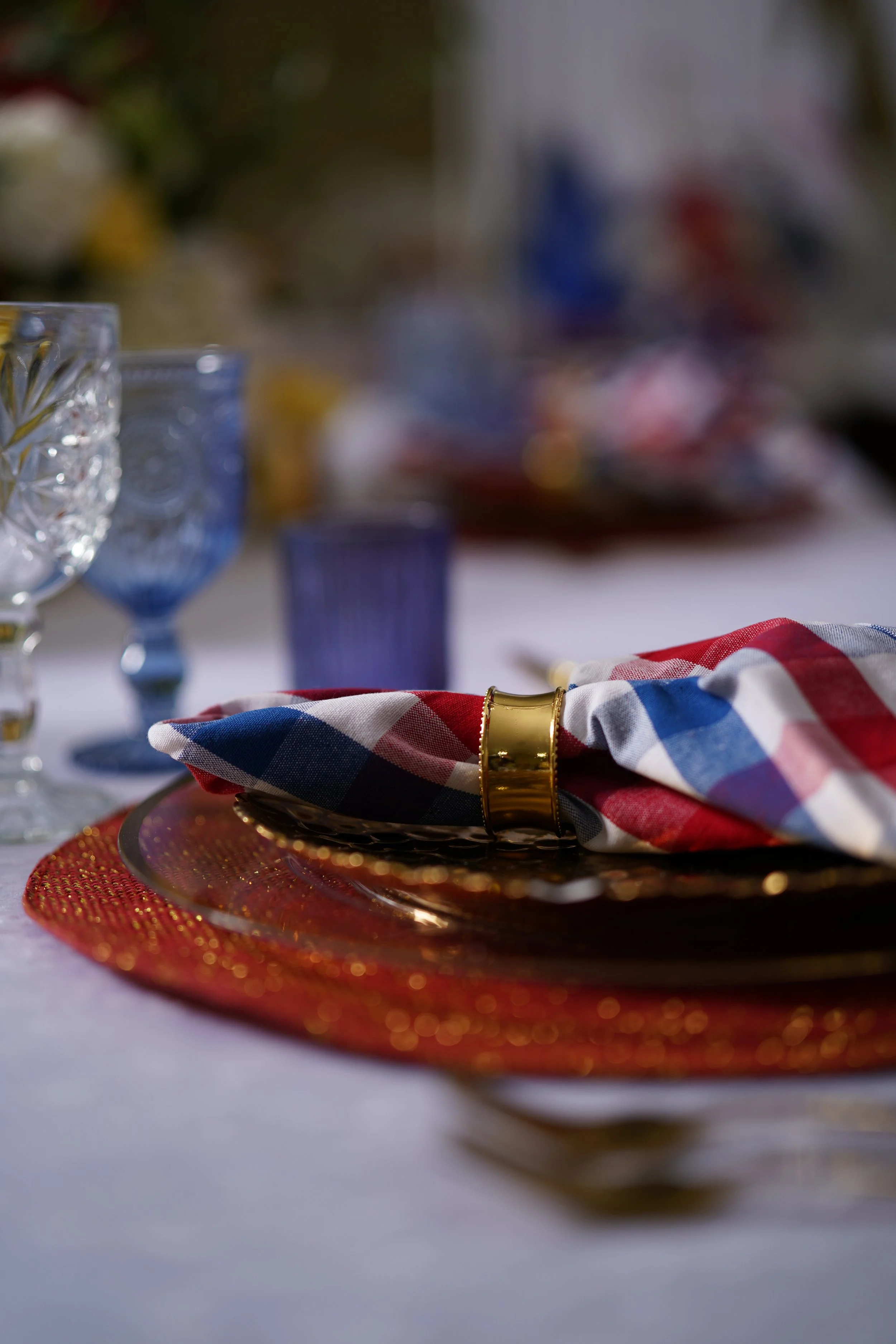 4th of July tablescape, red, white, blue napkin, blue accessories, gold plates, red placemats