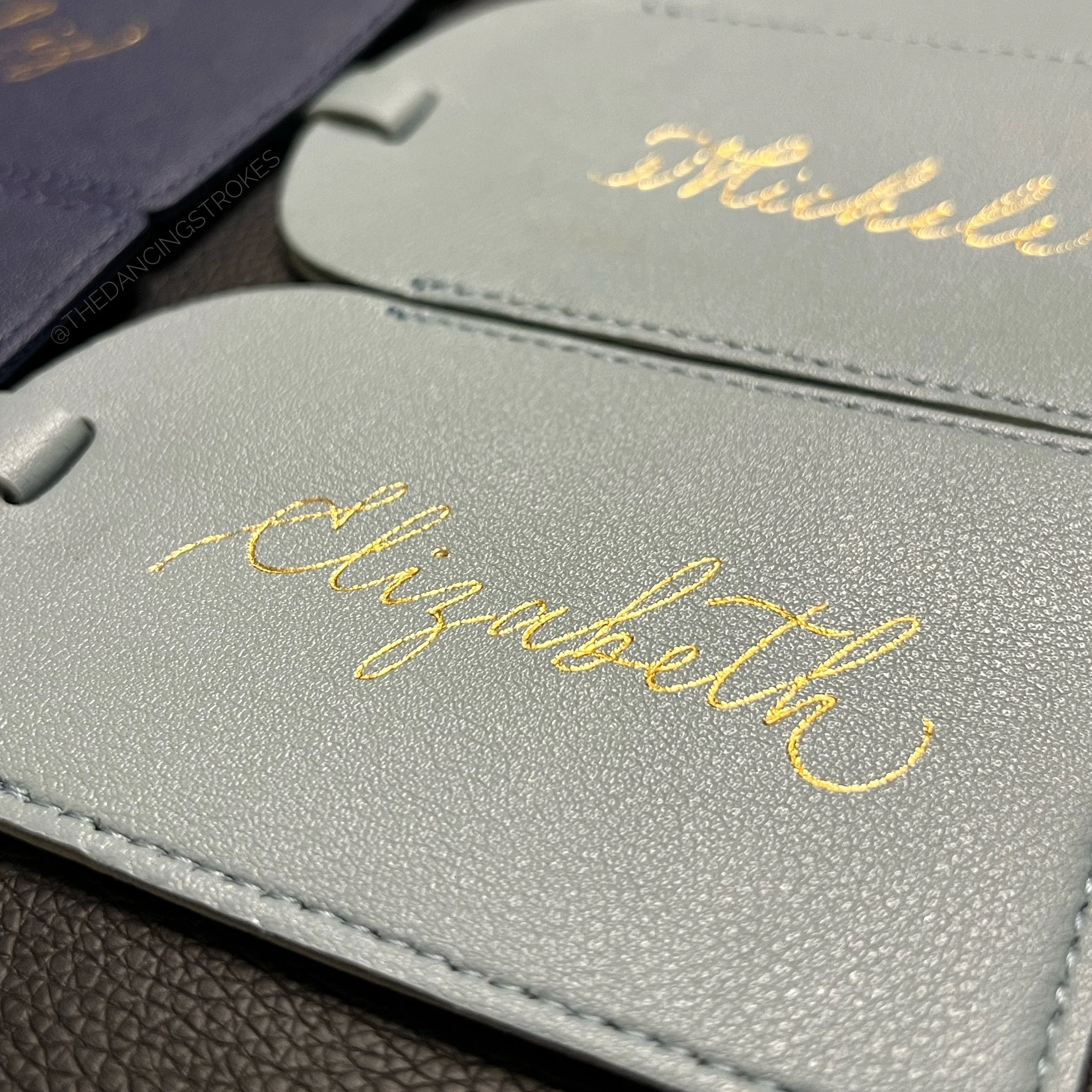 Hot foil personalization of luggage tags with names Vancouver caligrapher