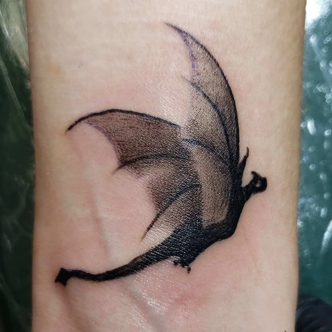 Black dragon tattoo on skin