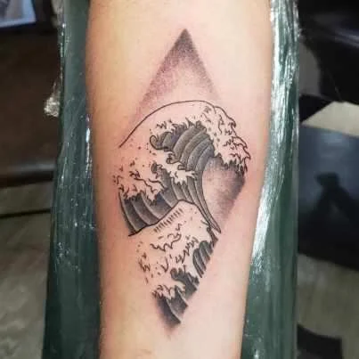 Tattoo of a stylized ocean wave inside a diamond shape on a person's arm.
