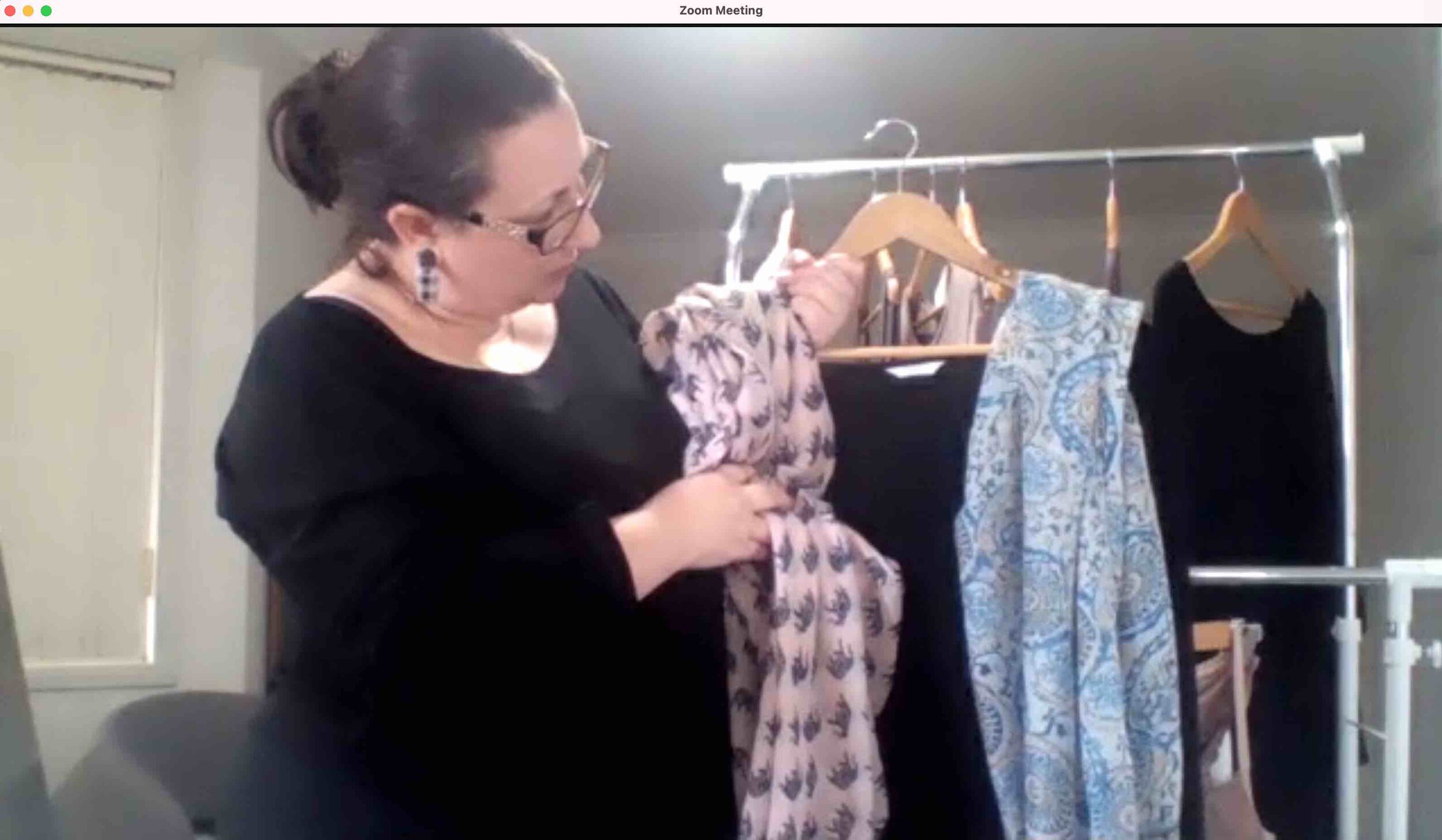 caucasian woman wearing black is trying a blue and a pink scarf with a top