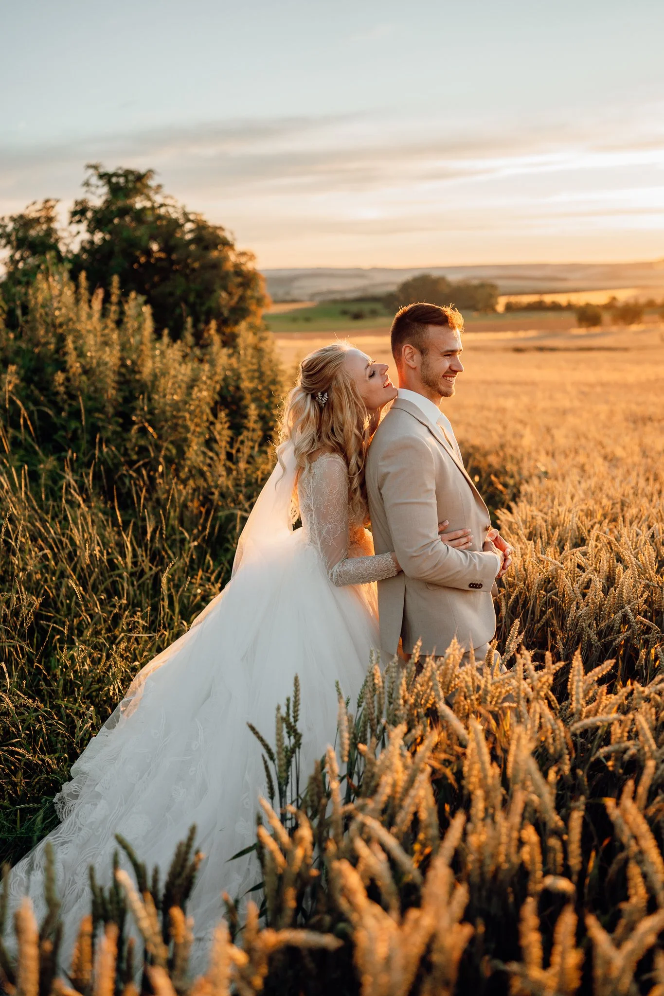 Svatební pár při západu slunce v poli - přirozená svatební fotografie od svatební fotografky z Brna. 