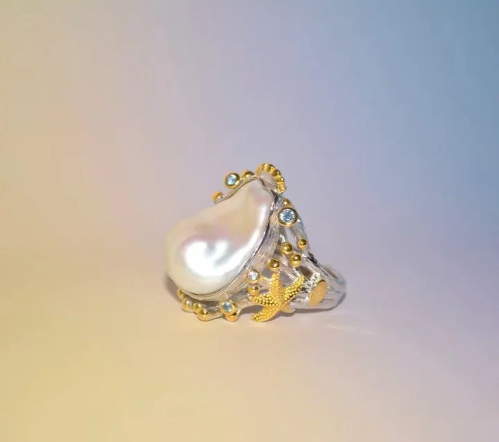 Marine captures a coastal feel with pearl details, ocean-inspired accents, and bright blue topaz!

#carolinawongjewellery #sustainable
#handmadejewellery #pearl #ring