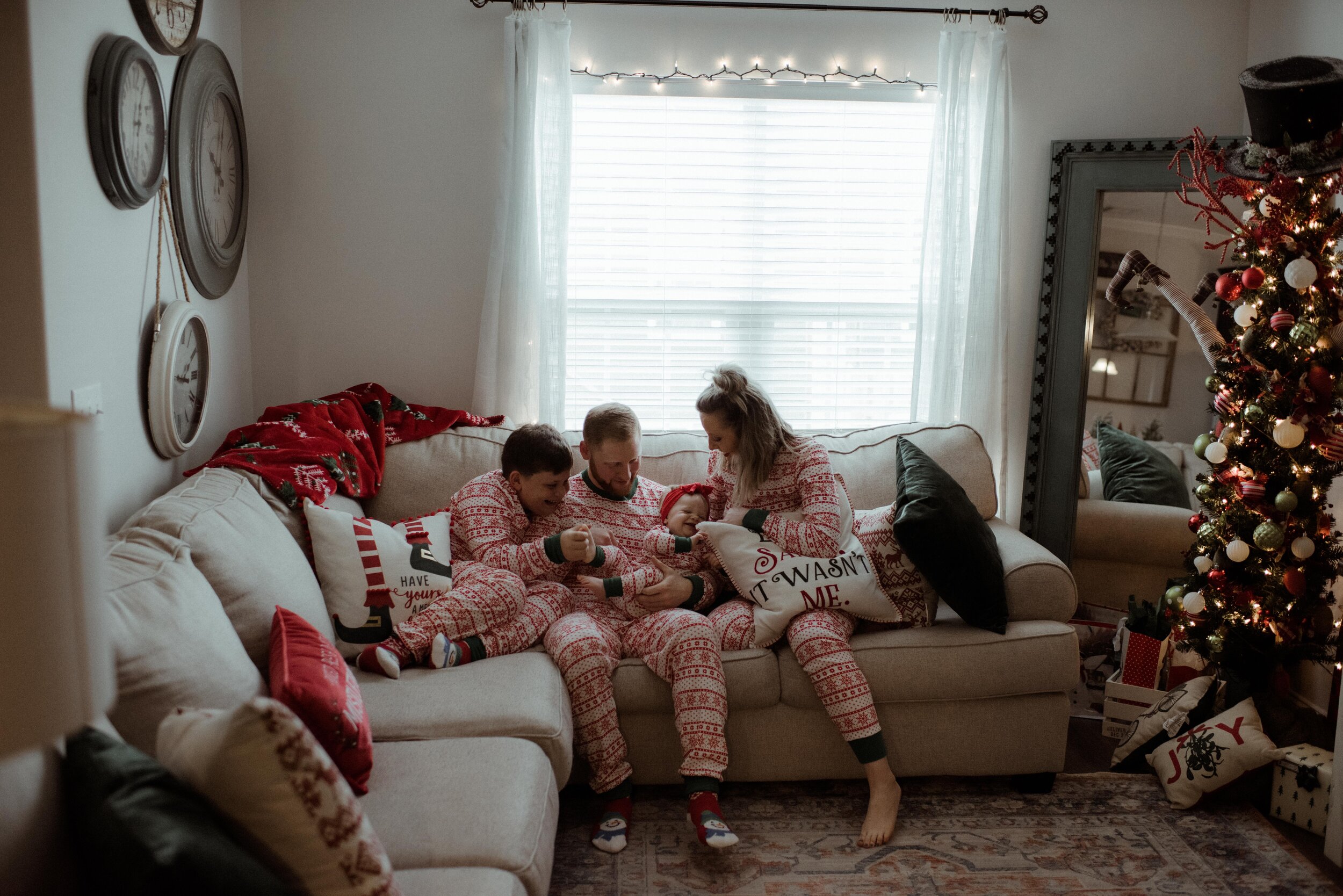 family-tickles-baby-on-couch-savannah-in-home-session.jpg