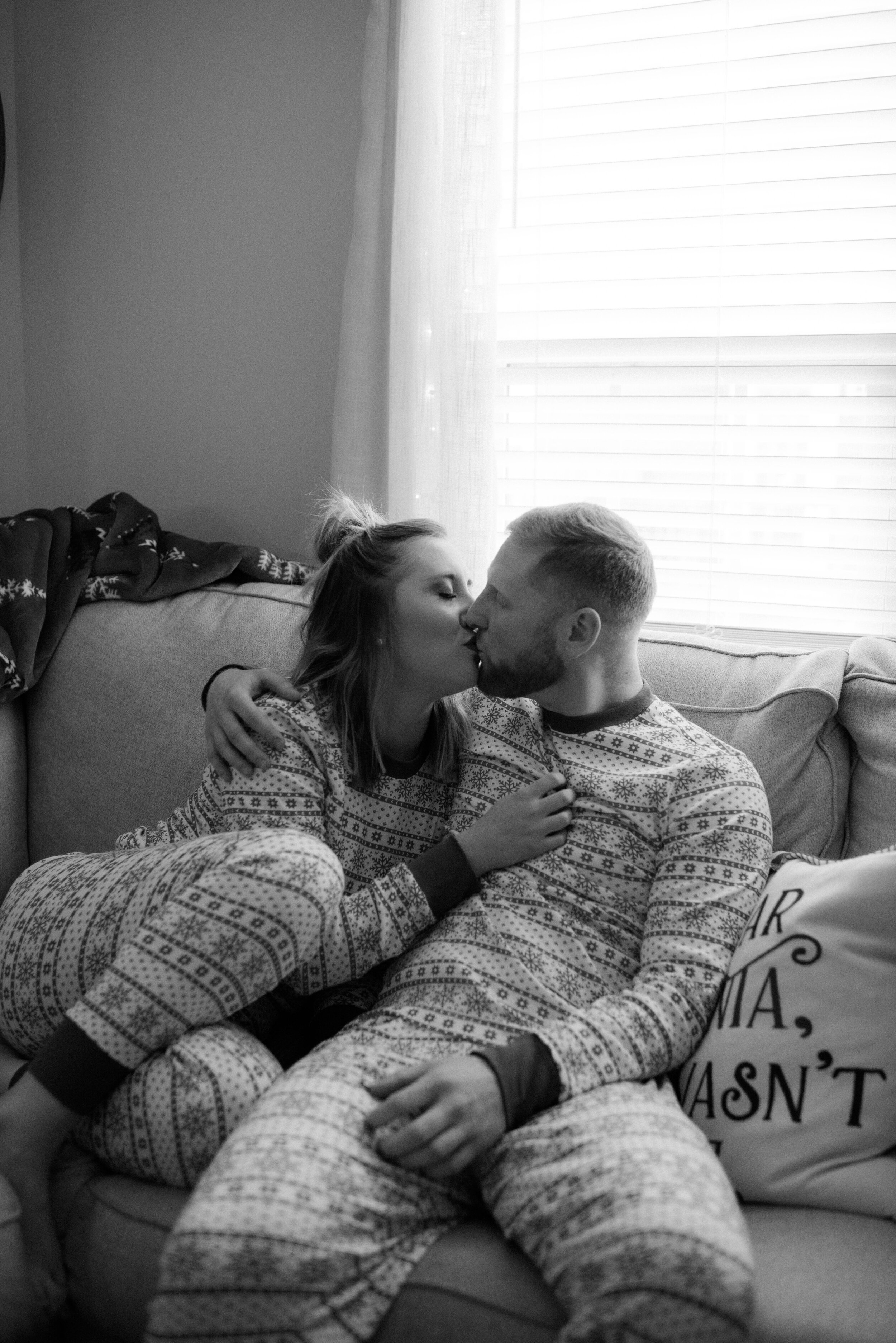 mom-and-dad-kiss-on-couch-christmas-in-home.jpg