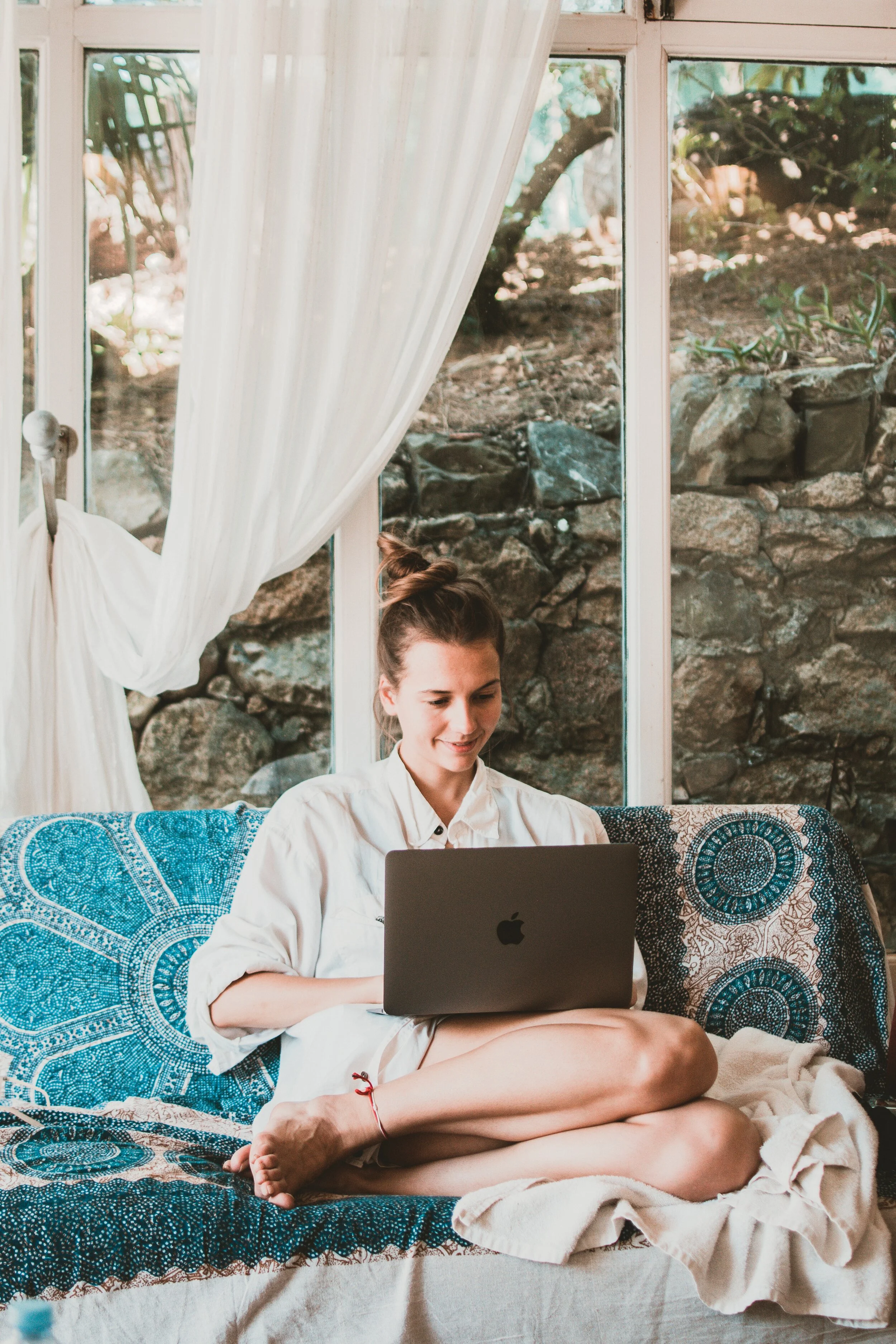 smiling-woman-using-macbook-while-sitting-on-sofa-1546329 (1).jpg