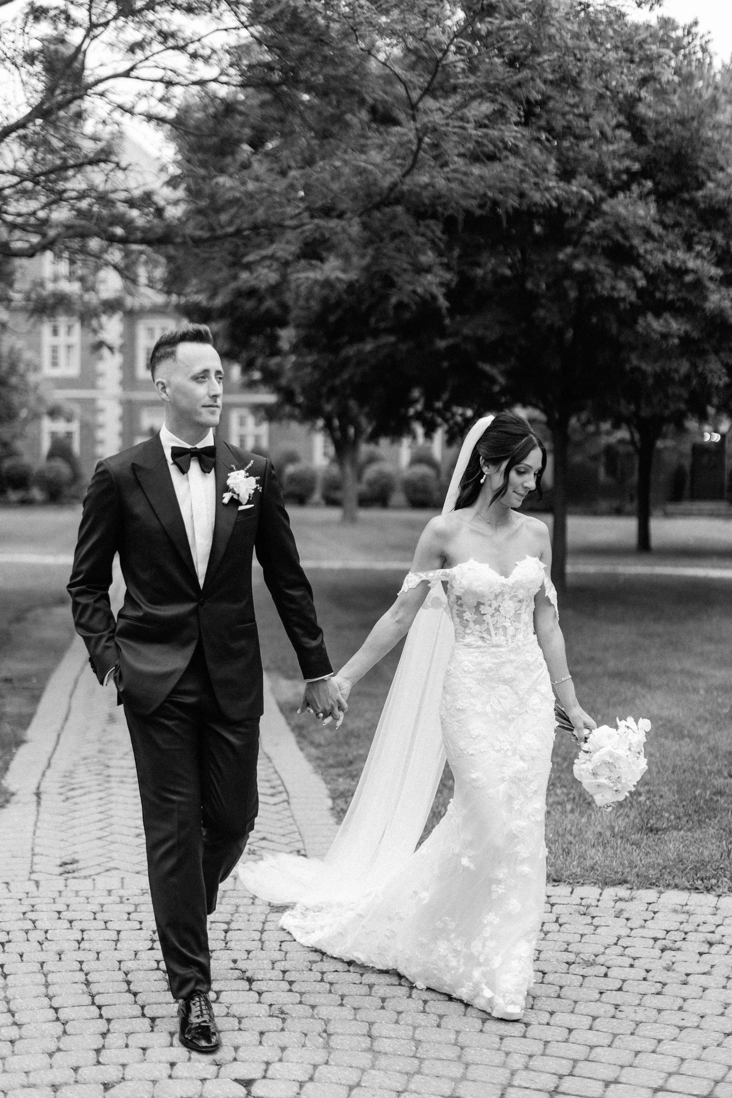Bride and Groom walking down a cobblestone path at Ridley College in Niagara on the Lake